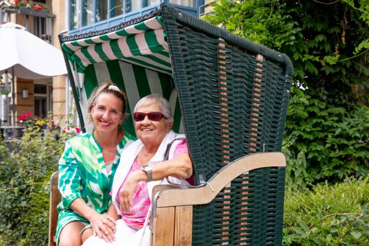 Doris Stock mit ihrer Tochter Claudia Voss im Strandkorb des Außenbereichs bei PFLEGEN & WOHNEN am Standort Moosberg.