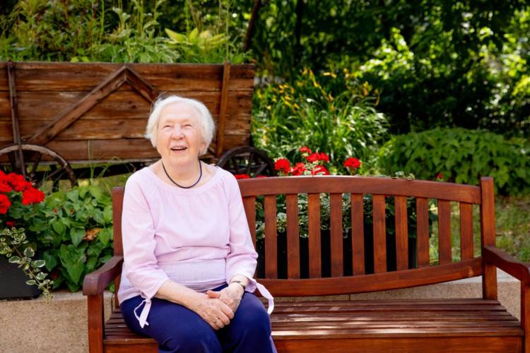 Ilse Mraz, Bewohnerin bei PFLEGEN & WOHNEN HAMBURG auf einer Bank im Außenbereich des Standorts Finkenau.