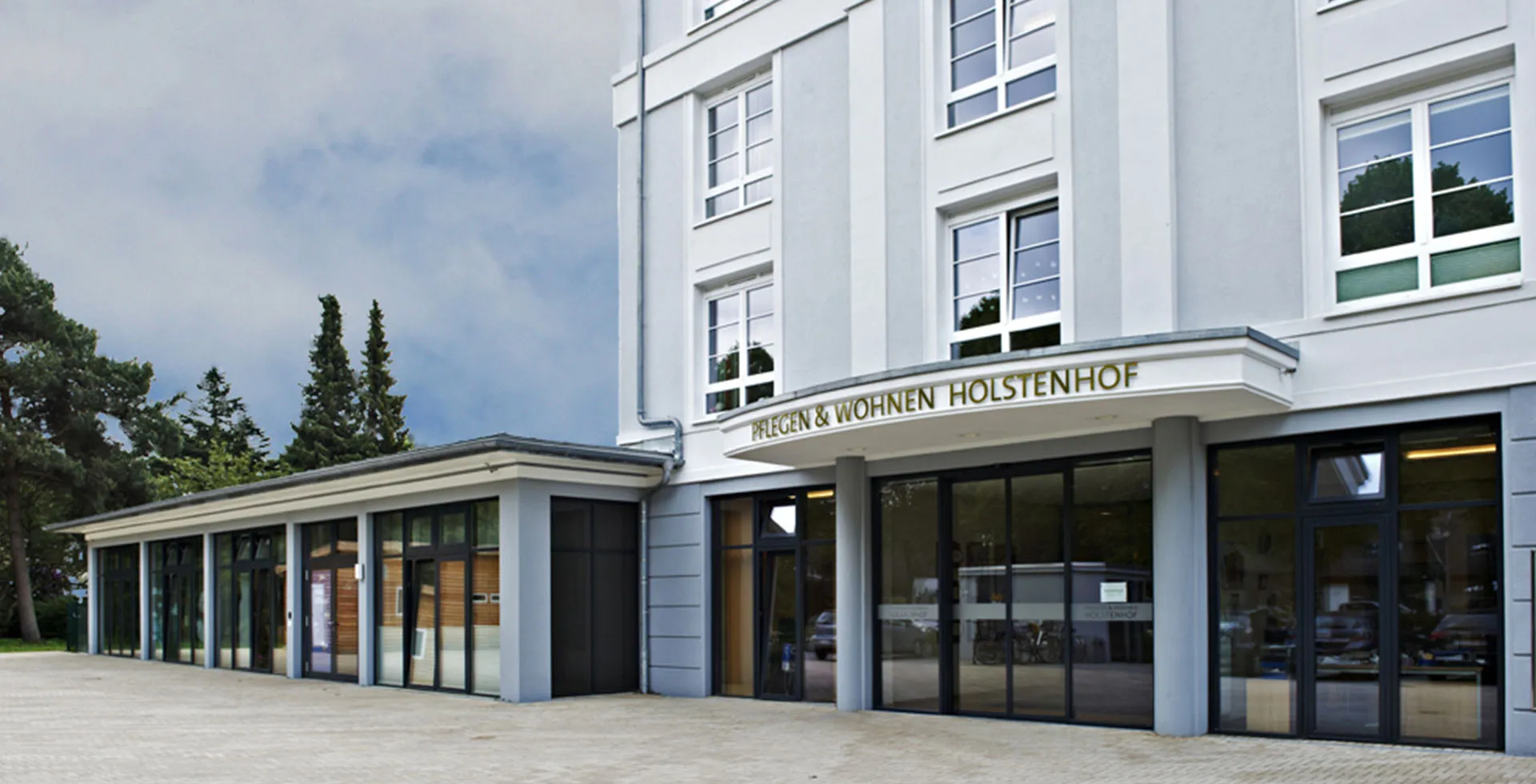 Außenansicht von PFLEGEN & WOHNEN HAMBURG Holstenhof mit Haupteingang für Ihre Anliegen rund um Betreuung und Pflegebedarf.