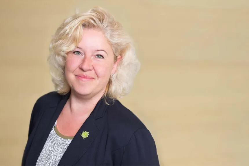 Porträt: Leslie Günther, fachkompetente Einrichtungsleitung von PFLEGEN & WOHNEN HAMBURG Heimfeld, vor hellem Hintergrund.