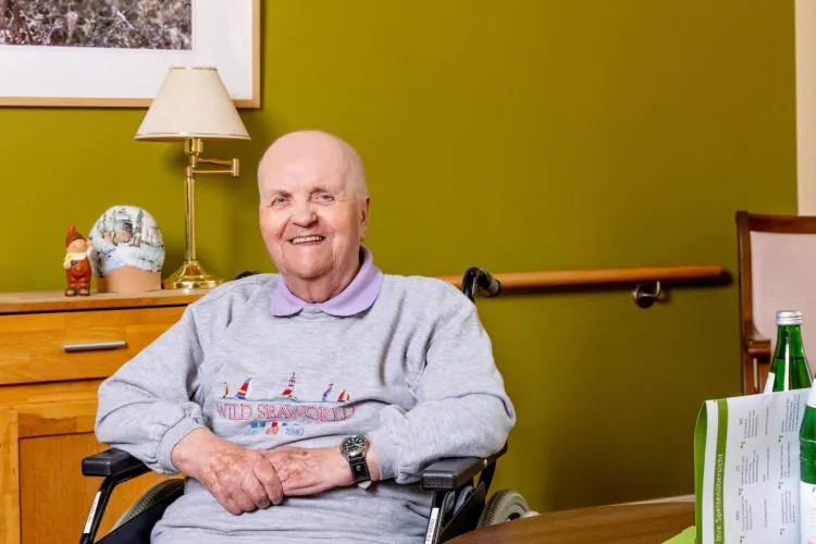 Uwe Köpke, Bewohner bei PFLEGEN & WOHNEN HAMBURG, am Tisch am Standort Heimfeld, weiß die nette und liebevolle Pflege zu schätzen.