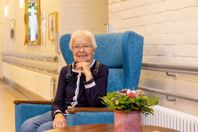 Charlotte Winter, in einem Sessel bei PFLEGEN & WOHNEN HAMBURG, fühlt sich am Standort Altona gut aufgehoben.