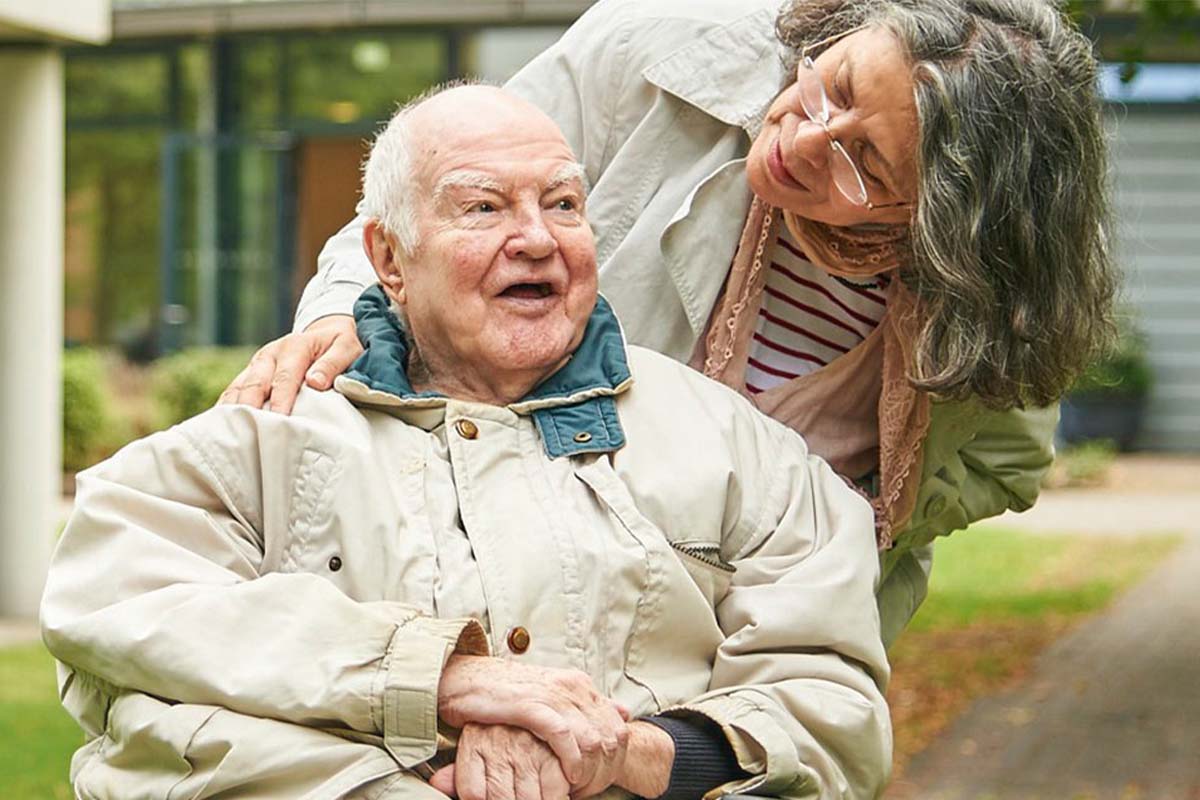 Älterer Mann im Garten, betreut von einer Frau bei PFLEGEN & WOHNEN HAMBURG.