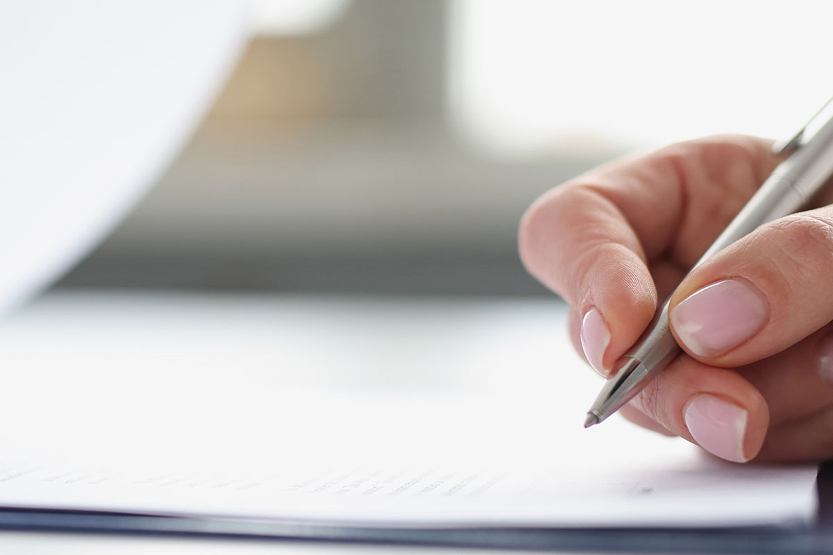 Eine Hand unterschreibt einen Vertrag