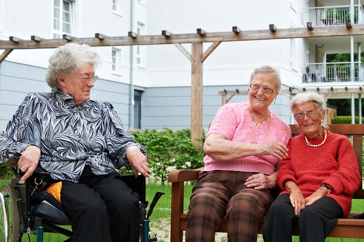 Bewohnerinnen im Außenbereich von PFLEGEN & WOHNEN HAMBURG Holstenhof, mit einem Fokus auf demenzerkrankte Menschen.